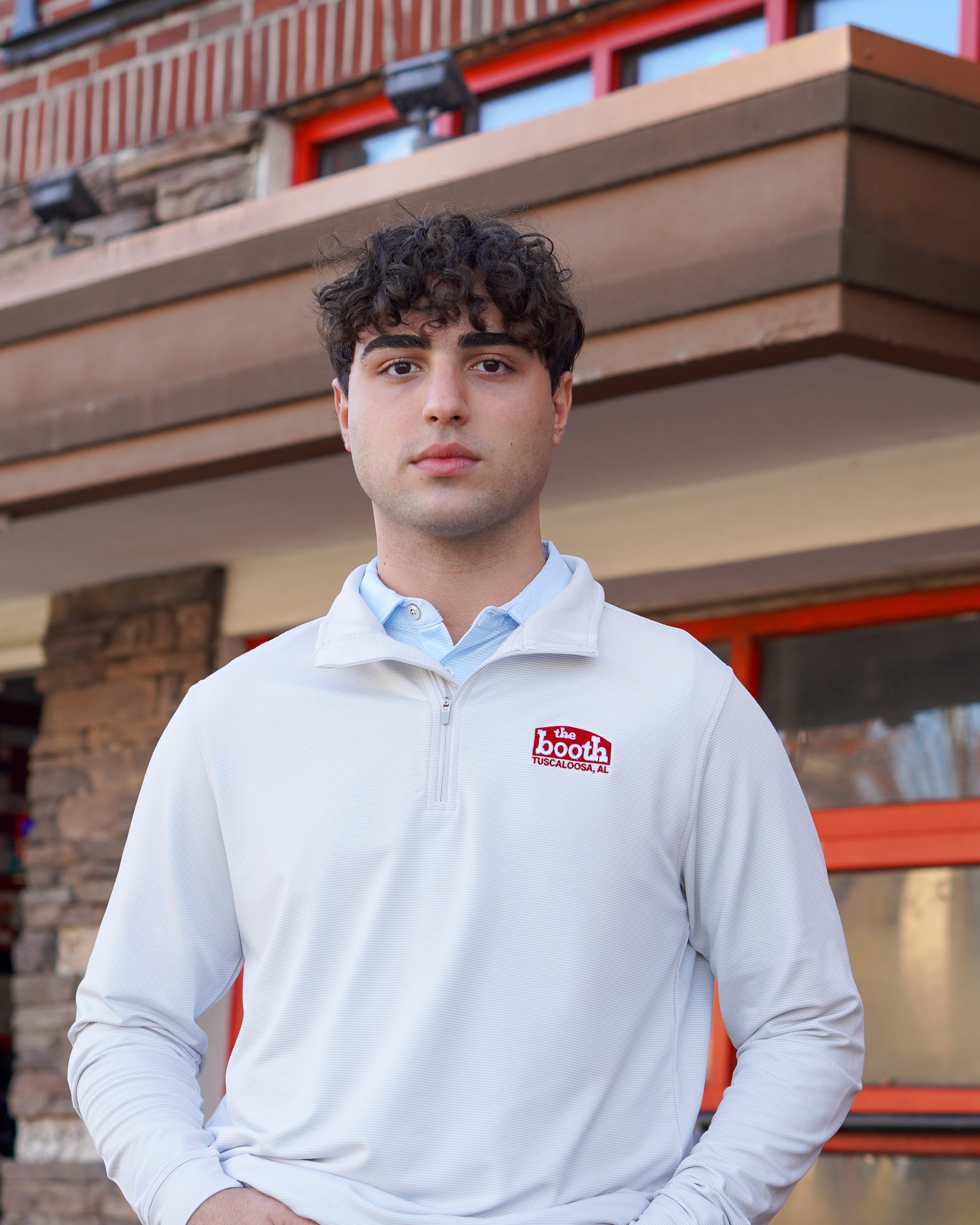 The Booth Light Blue Stripe Men’s Pullover with a Red The Booth Logo embroidered on the chest