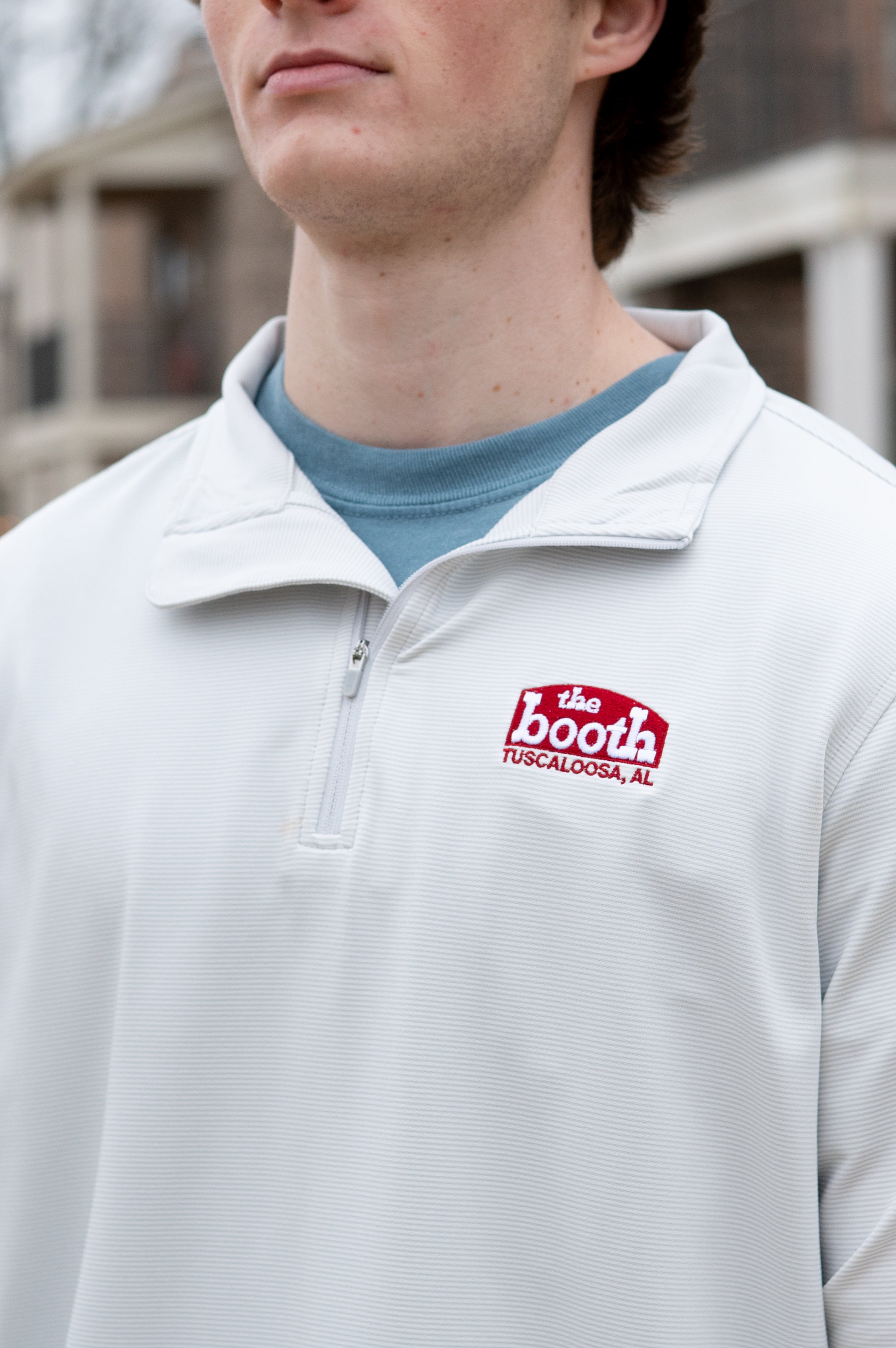 The Booth Light Blue Stripe Men’s Pullover with a Red The Booth Logo embroidered on the chest