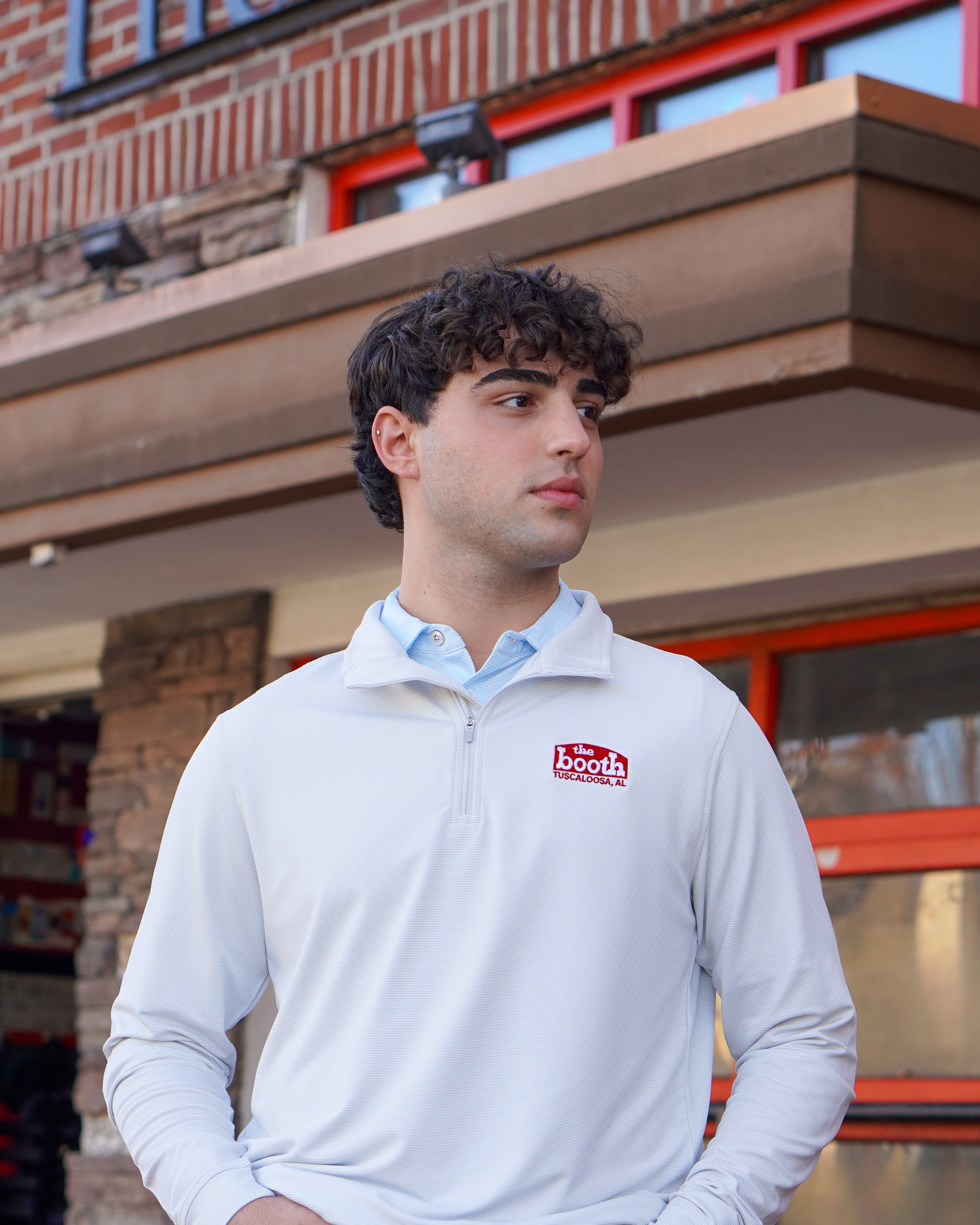 The Booth Light Blue Stripe Men’s Pullover with a Red The Booth Logo embroidered on the chest