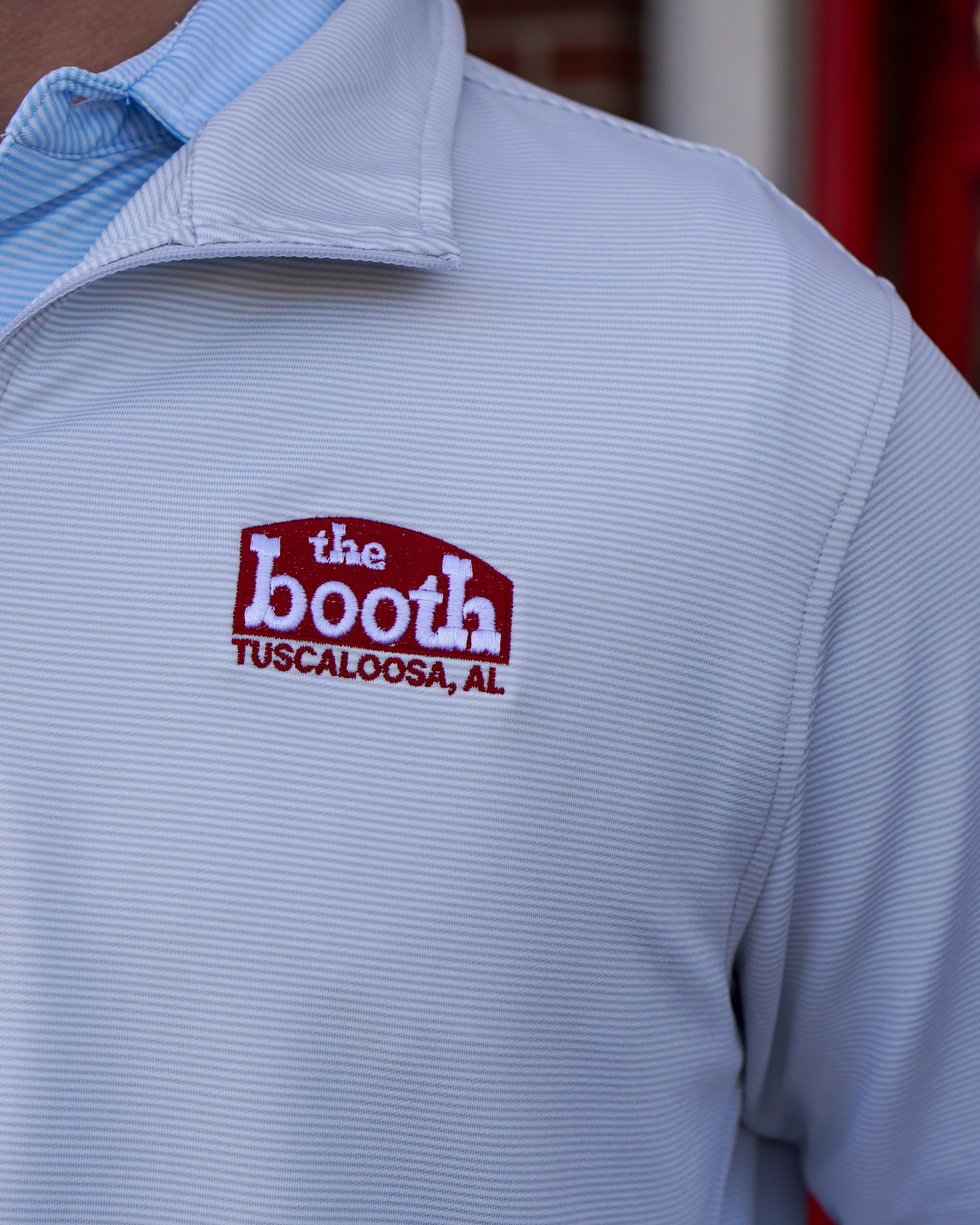 The Booth Light Blue Stripe Men’s Pullover with a Red The Booth Logo embroidered on the chest