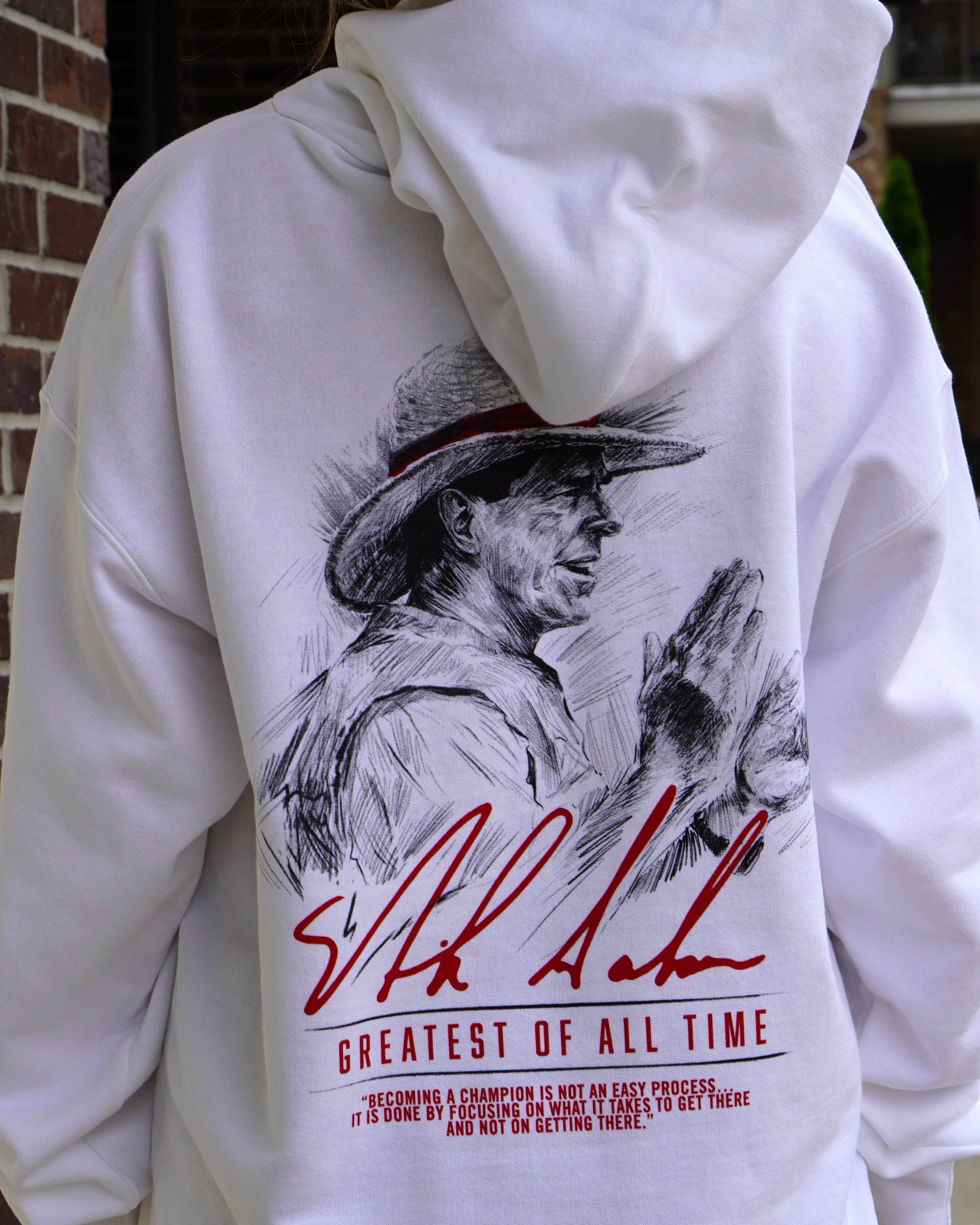 University of Alabama White Hanes Hoodie with an illustration of Nick Saban above his signature and Red text "Greatest Of All Time"