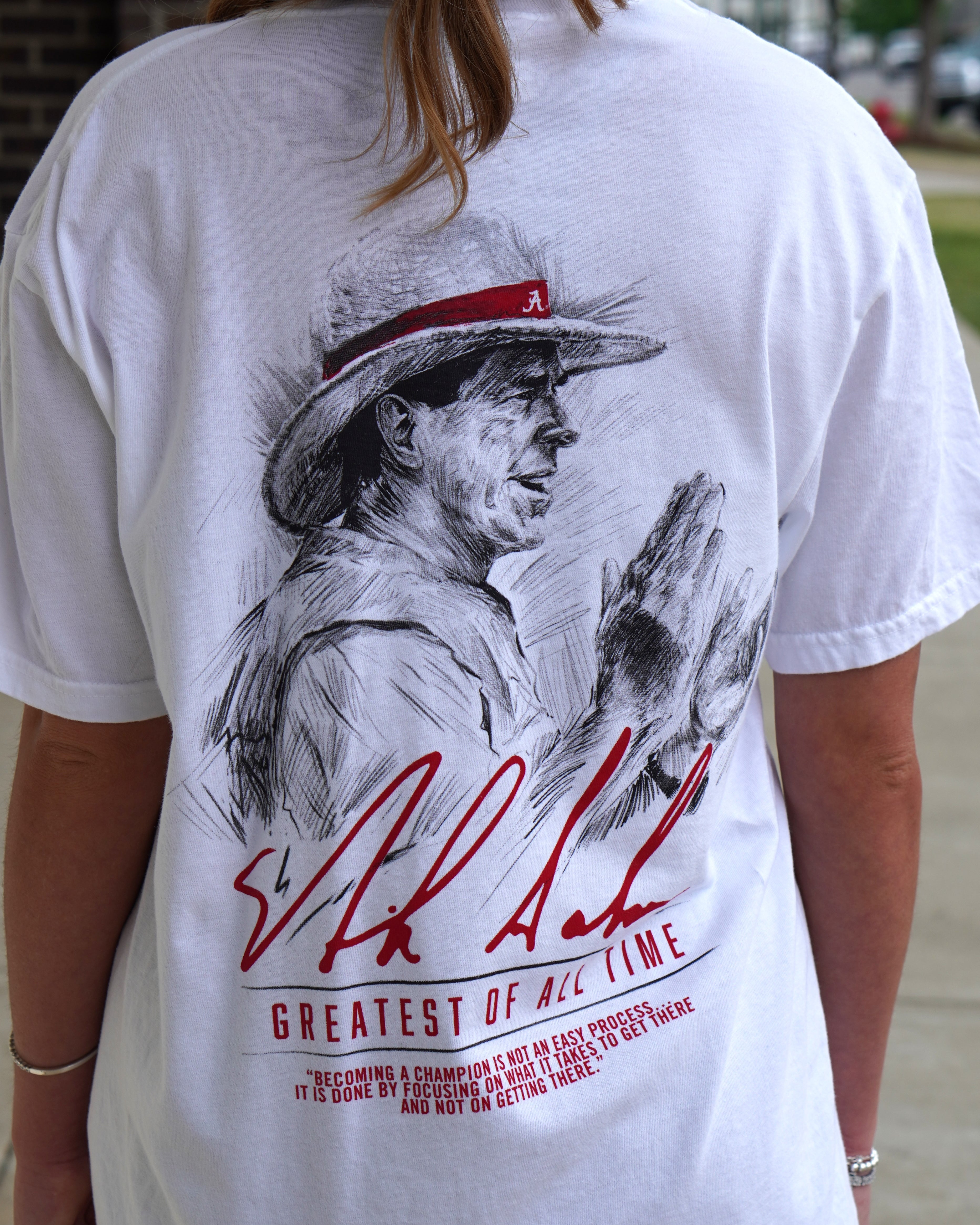 University of Alabama White Comfort Colors T-Shirt with an illustration of Nick Saban above his signature and Red text "Greatest Of All Time"