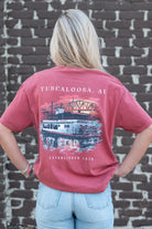 Tuscaloosa Red T-Shirt with White text "Tuscaloosa, AL" above  an illustration of a riverboat sailing underneath the Tuscaloosa Trestle as the sun sets