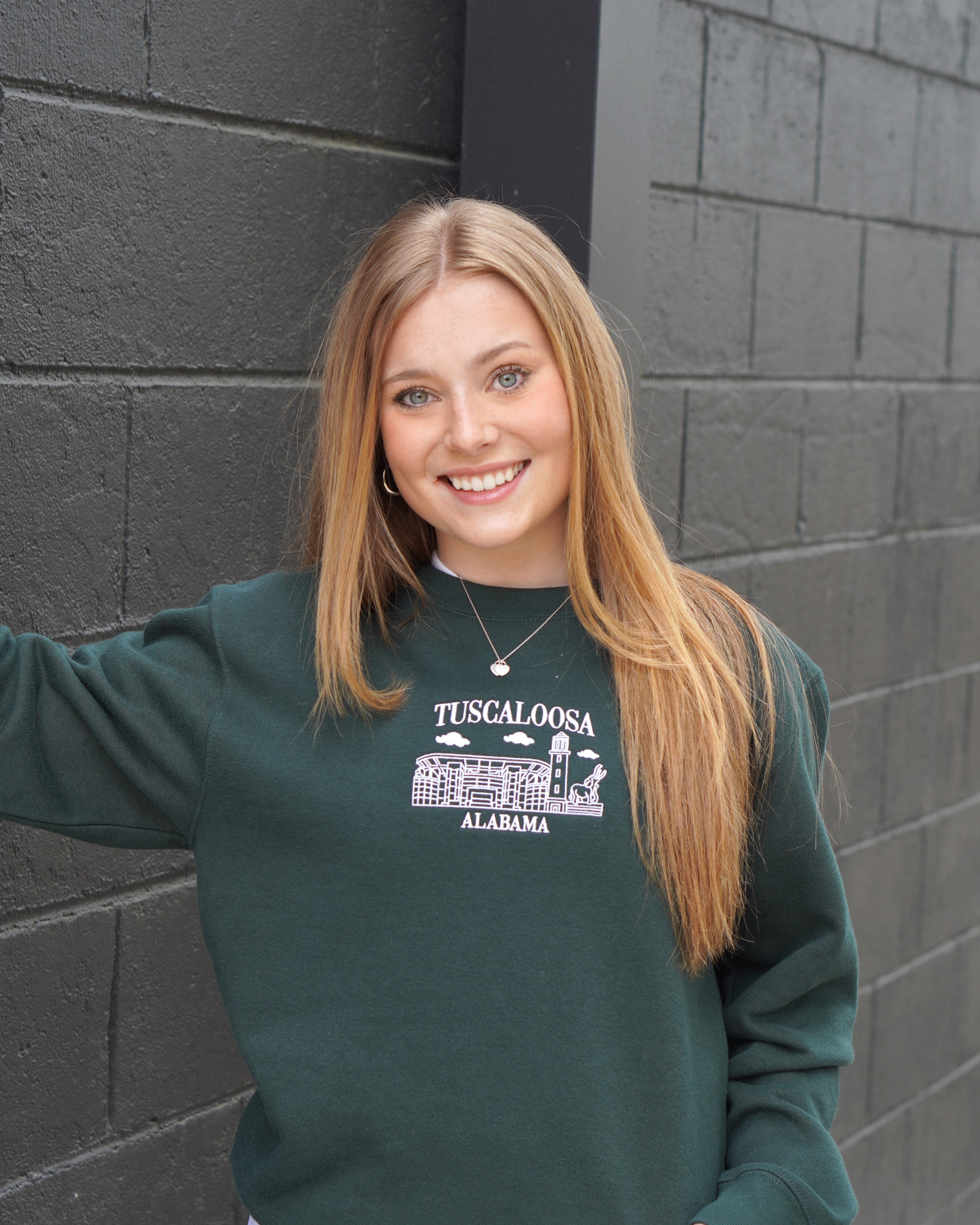 University of Alabama Tuscaloosa Landmarks Dark Green Lane Seven Ladies' Sweatshirt with White embroidery of Tuscaloosa landmarks under text "Tuscaloosa"