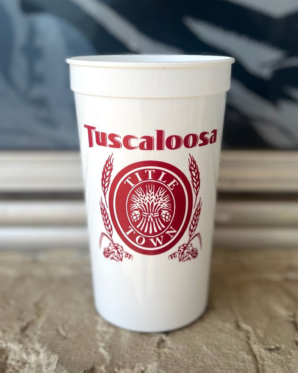 Tuscaloosa White Stadium Cup with Red text "Tuscaloosa" above the Red and White Title Town emblem, a bundle of wheat with the words "Title Town" circling it