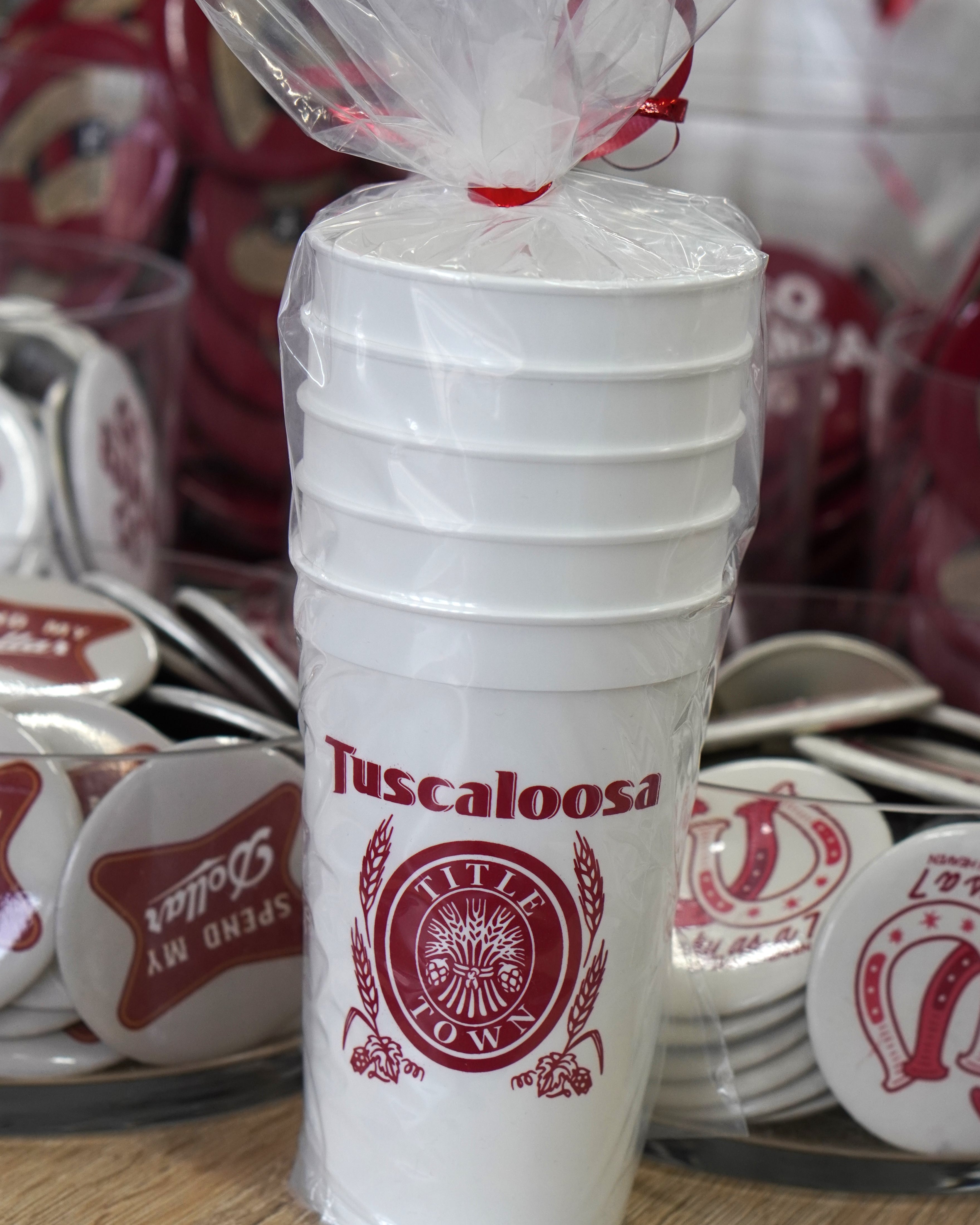 Tuscaloosa White Stadium Cup with Red text "Tuscaloosa" above the Red and White Title Town emblem, a bundle of wheat with the words "Title Town" circling it