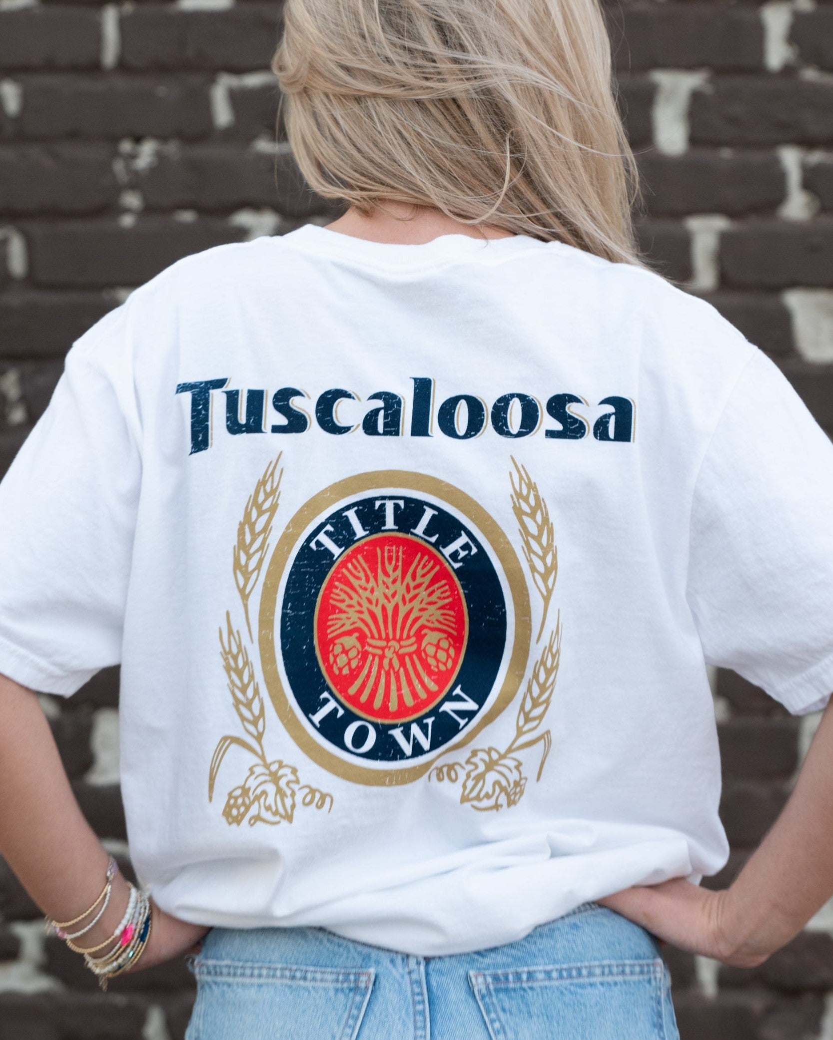 Tuscaloosa White T-Shirt with Navy text "Tuscaloosa" above the Title Town emblem