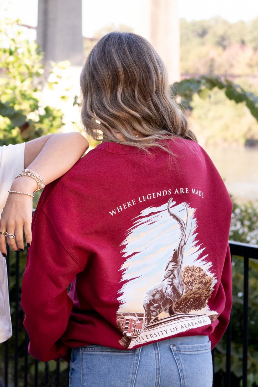 University of Alabama Red Sweatshirt with an image of the Tuska Statue underneath White text "Where Legends Are Made"