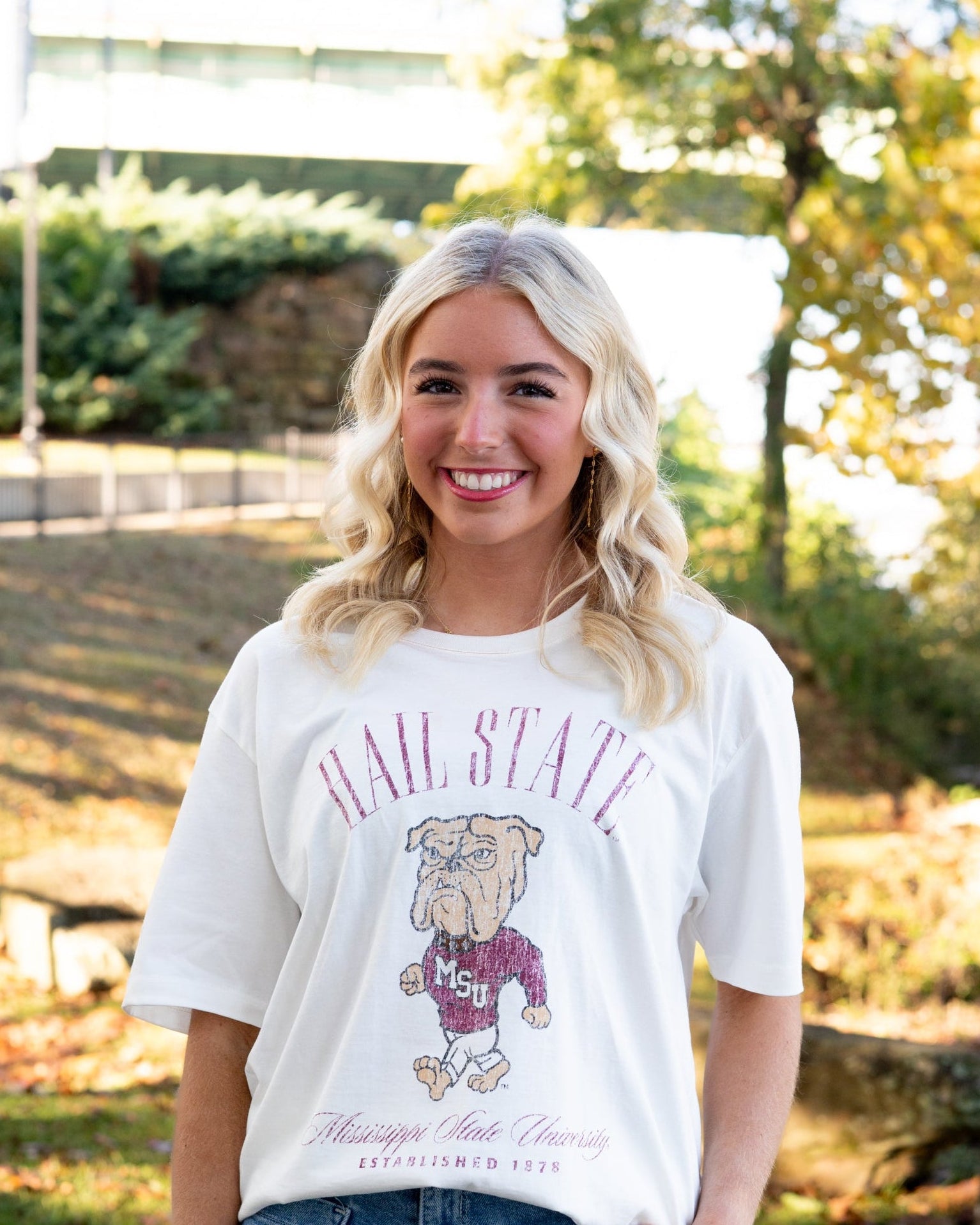 Mississippi State Ivory T-Shirt with Red text “Hail State” above an image of the Walking Bully Logo