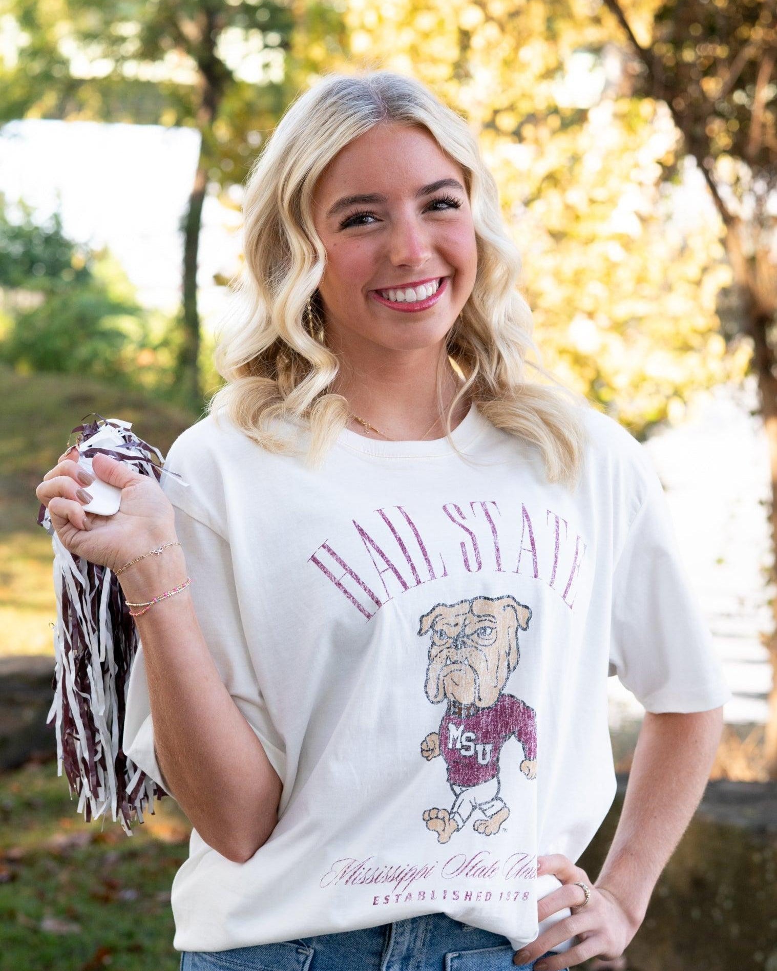 Mississippi State Ivory T-Shirt with Red text “Hail State” above an image of the Walking Bully Logo