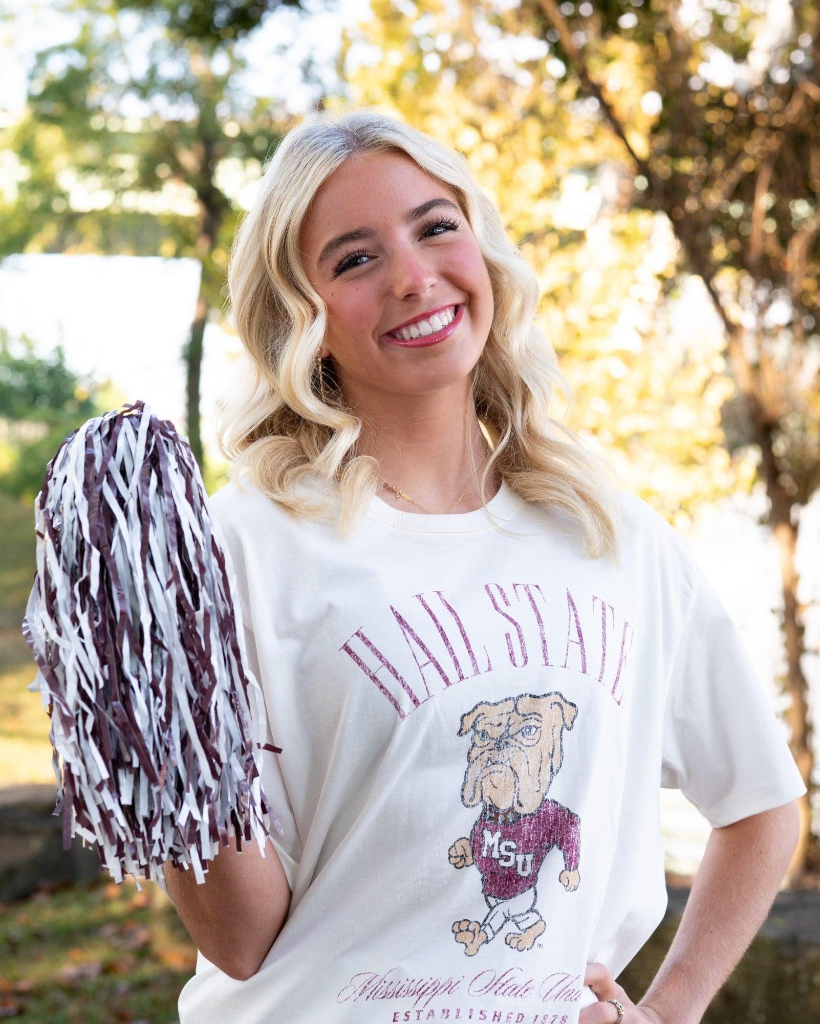 Mississippi State Ivory T-Shirt with Red text “Hail State” above an image of the Walking Bully Logo