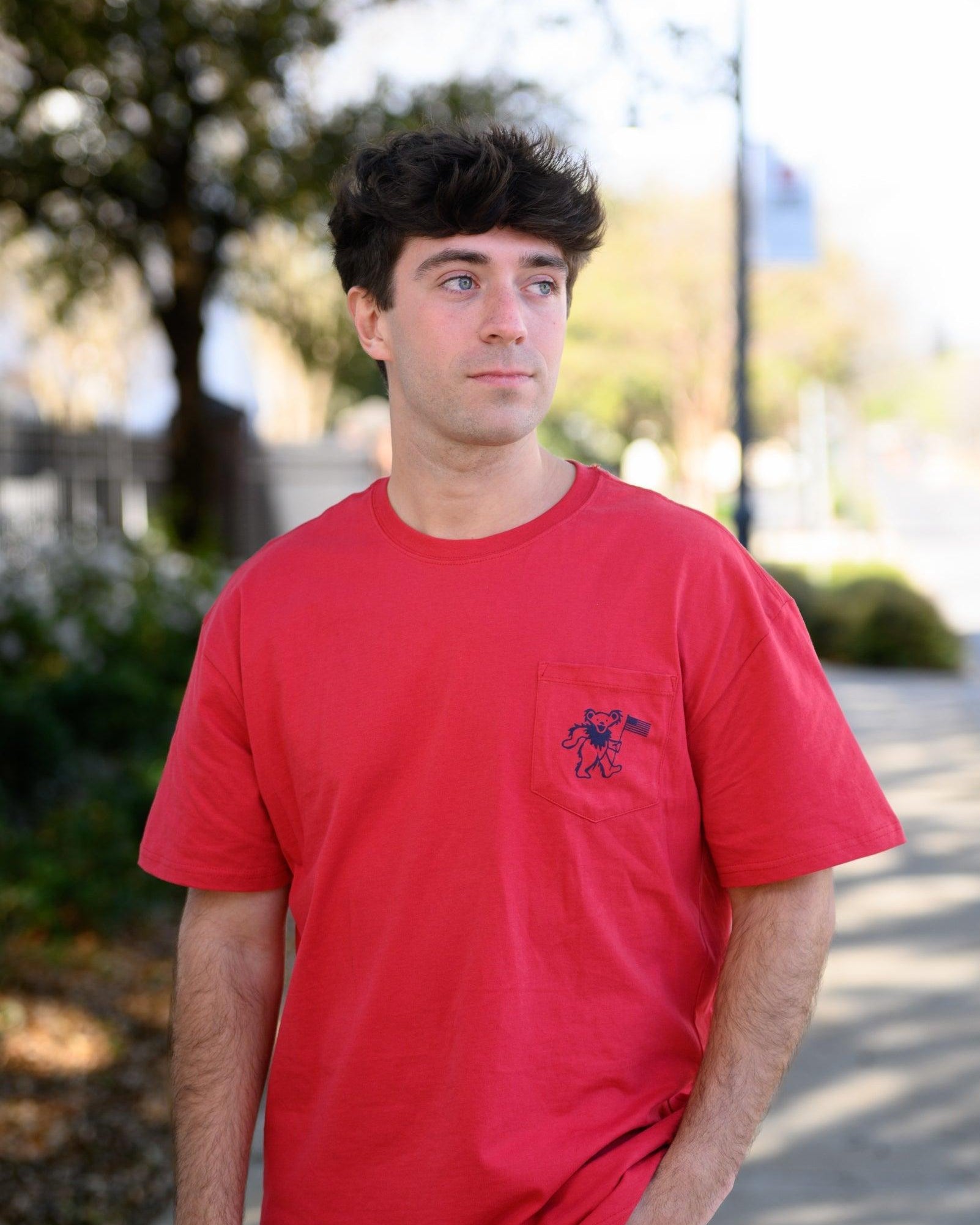 Grateful State Red T-Shirt with a front pocket design featuring a dancing bear holding a flag