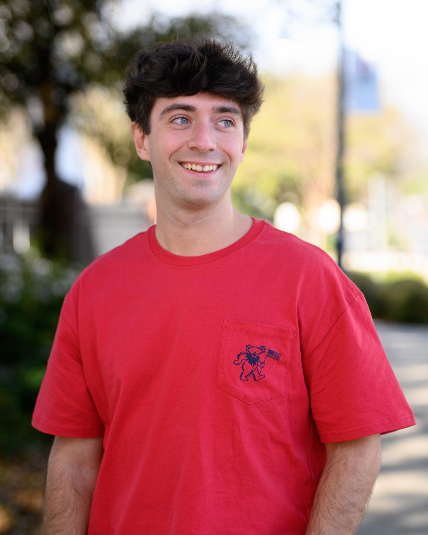 Grateful State Red T-Shirt with a front pocket design featuring a dancing bear holding a flag