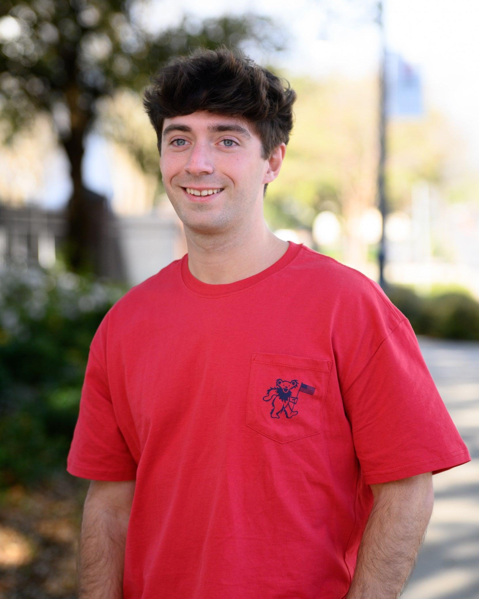 Grateful State Red T-Shirt with a front pocket design featuring a dancing bear holding a flag