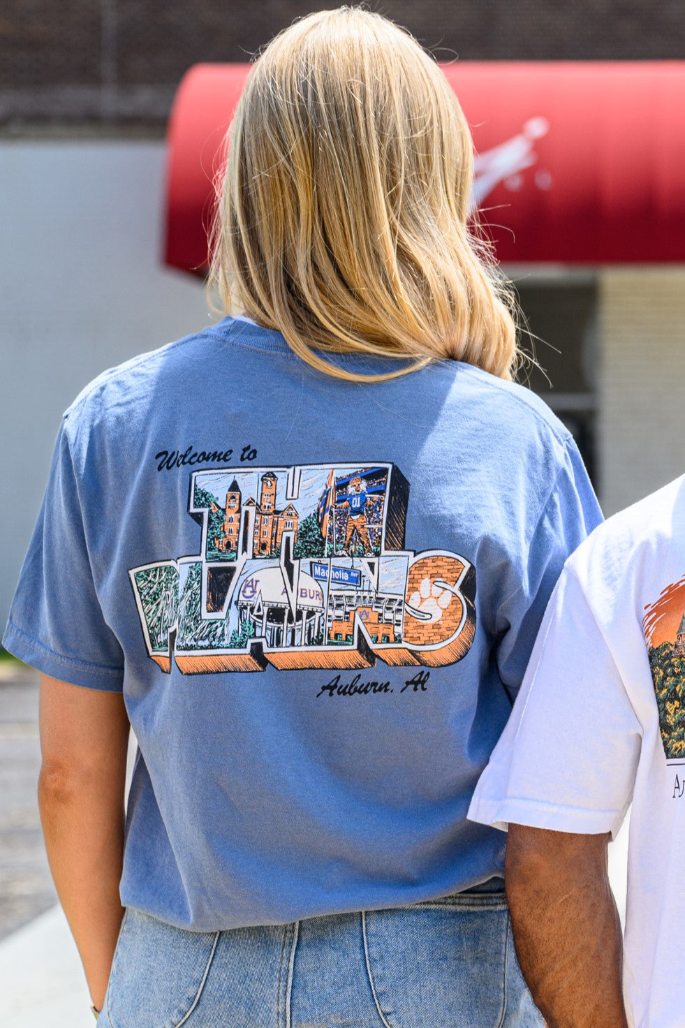 Auburn University Blue The Plains T-Shirt with postcard style text "Welcome to THE PLAINS" with "The Plains" filled with images of iconic buildings in that location