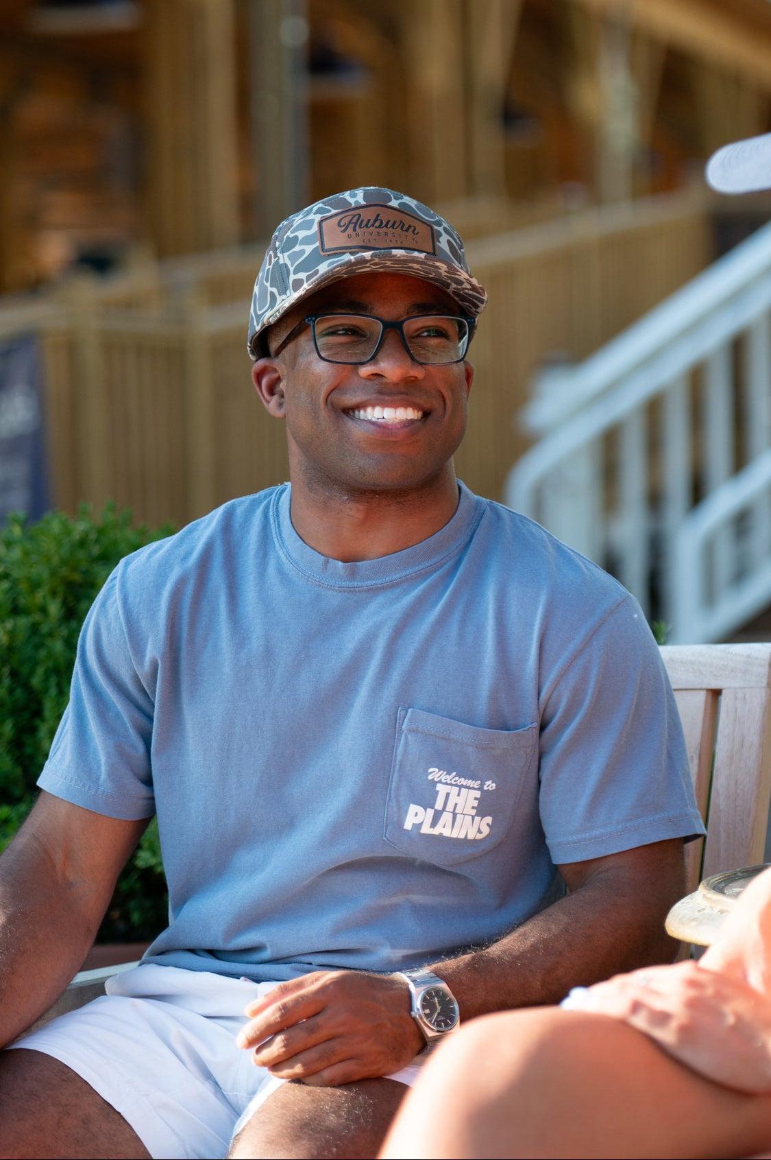 Auburn University Blue The Plains T-Shirt with postcard style text "Welcome to THE PLAINS" with "The Plains" filled with images of iconic buildings in that location