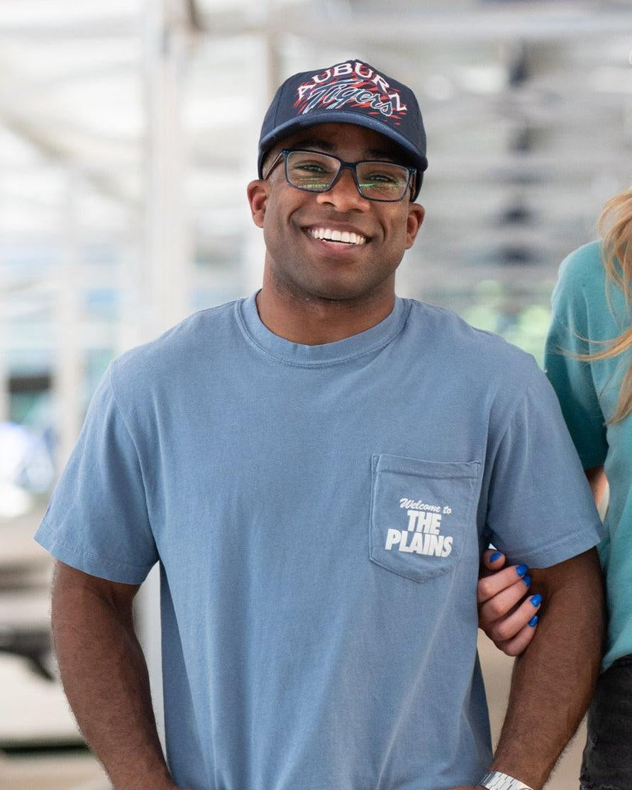 Auburn University Blue The Plains T-Shirt with postcard style text "Welcome to THE PLAINS" with "The Plains" filled with images of iconic buildings in that location