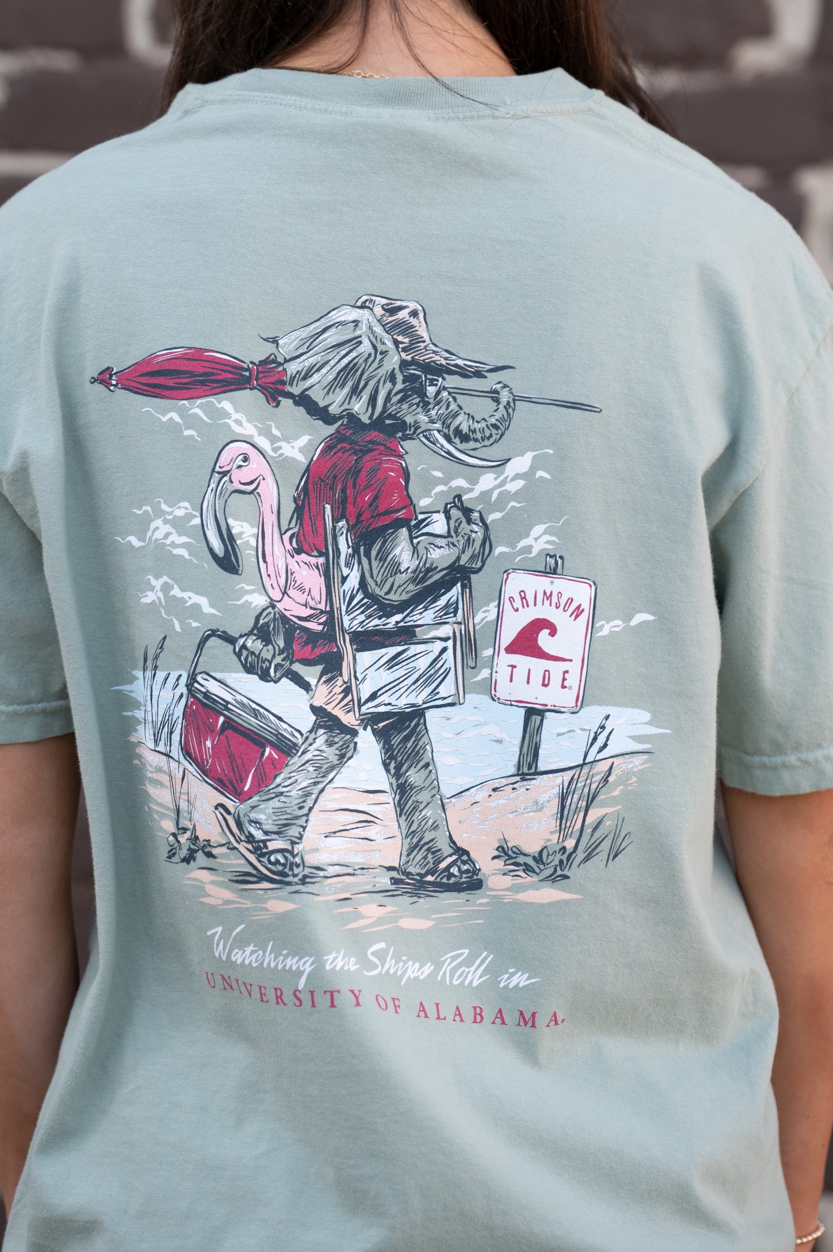 University of Alabama Big Al Beach Chalky Mint Comfort Colors T-Shirt with an image of Big Al in beach clothes carrying an umbrella dragging a cooler across the sand