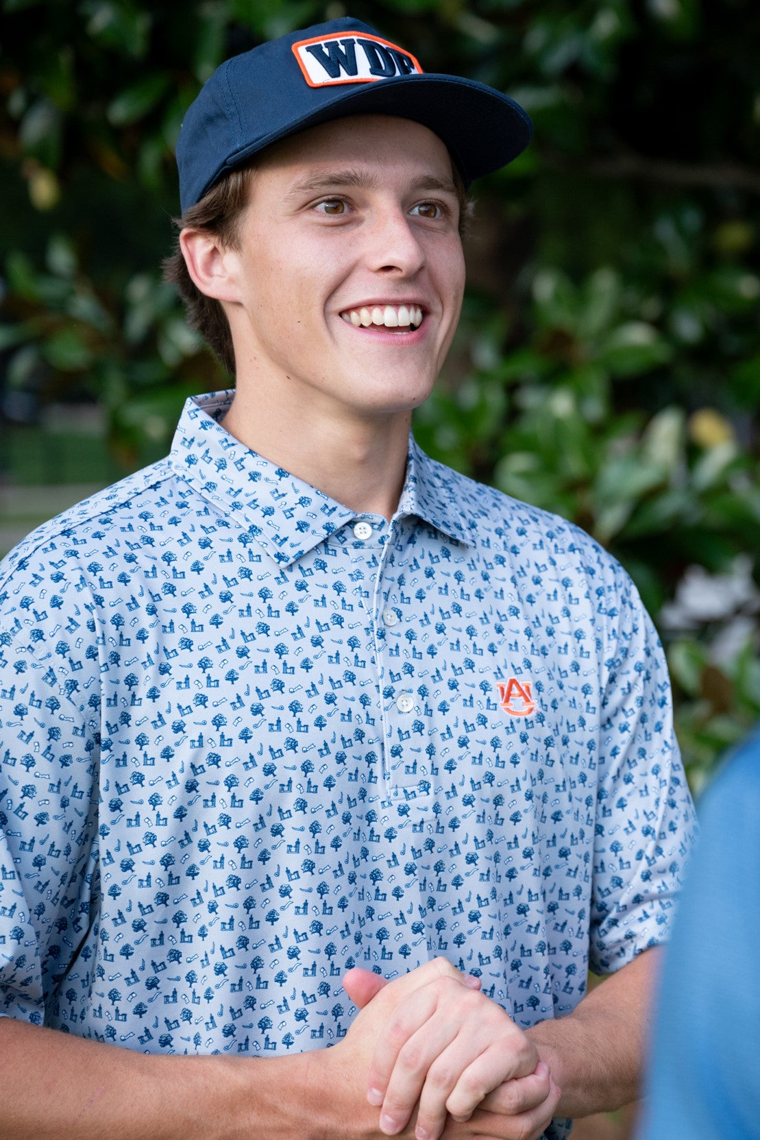 Auburn University Blue Men's Polo with a pattern of Toomers Corner Icons, and an embroidered Orange AU Logo
