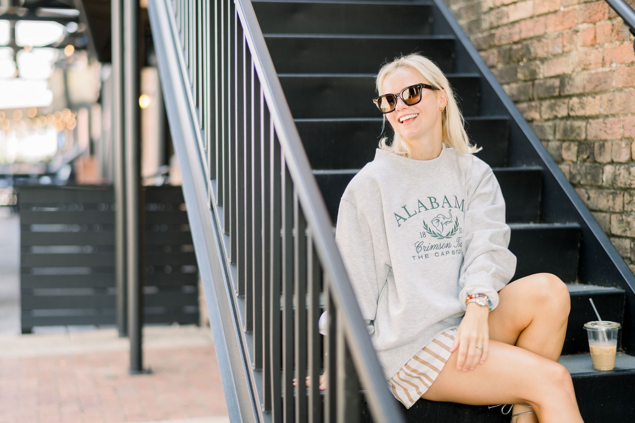University of Alabama Grey Mock Neck Sweatshirt with Green Embroidered text “Alabama” above the elephant crest (An elephant head outline encircled by a wreath of laurels), and text “Crimson Tide- The Capstone”