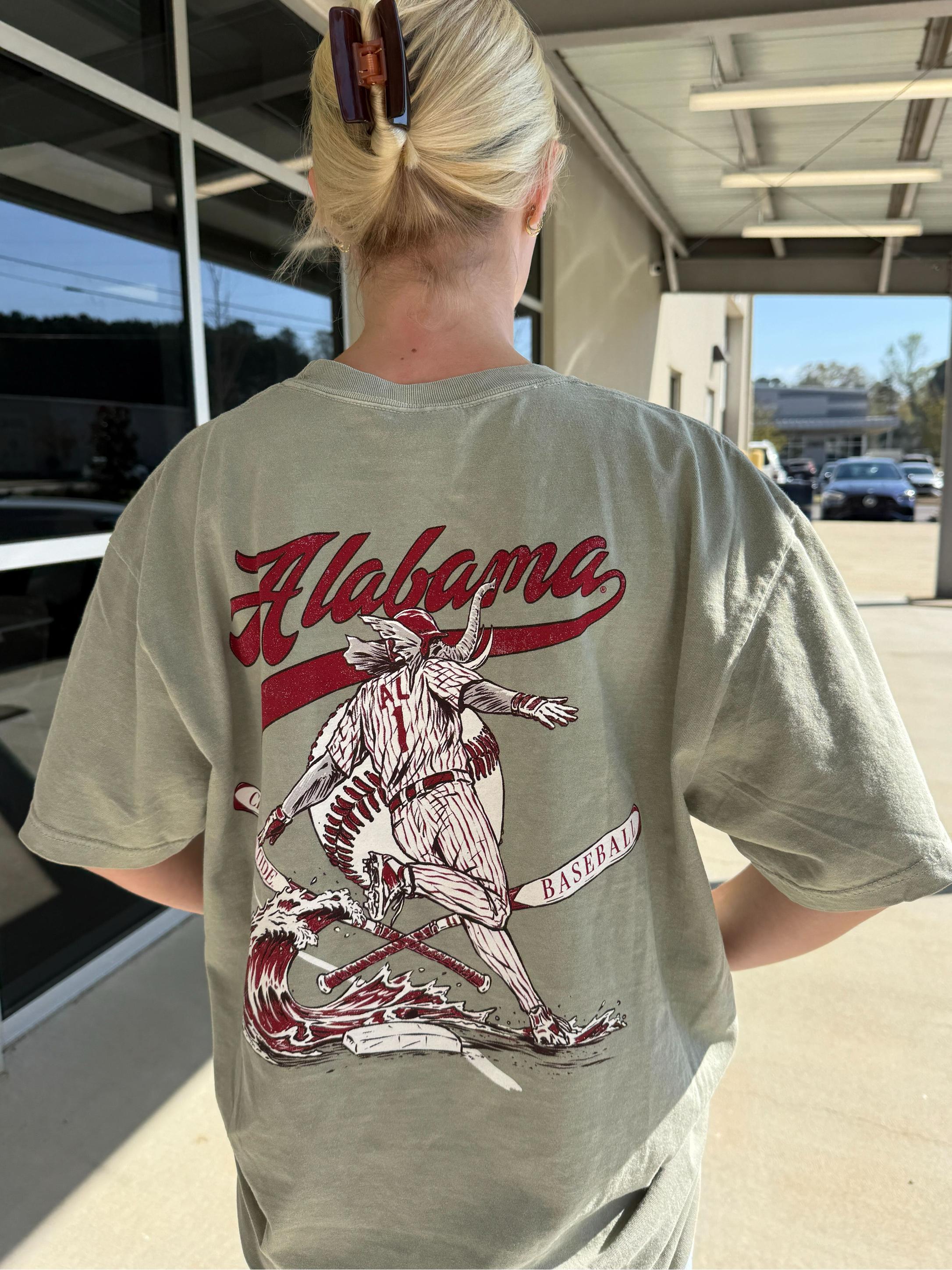 University of Alabama Tan T-Shirt with an image of Big Al running around a base with a Red Tidal Wave breaking over it and Red script “Alabama” above the image