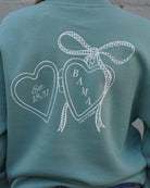 University of Alabama Seafoam Crewneck with cursive writing on the front and an open locket with the writing “Bama” inside on the back