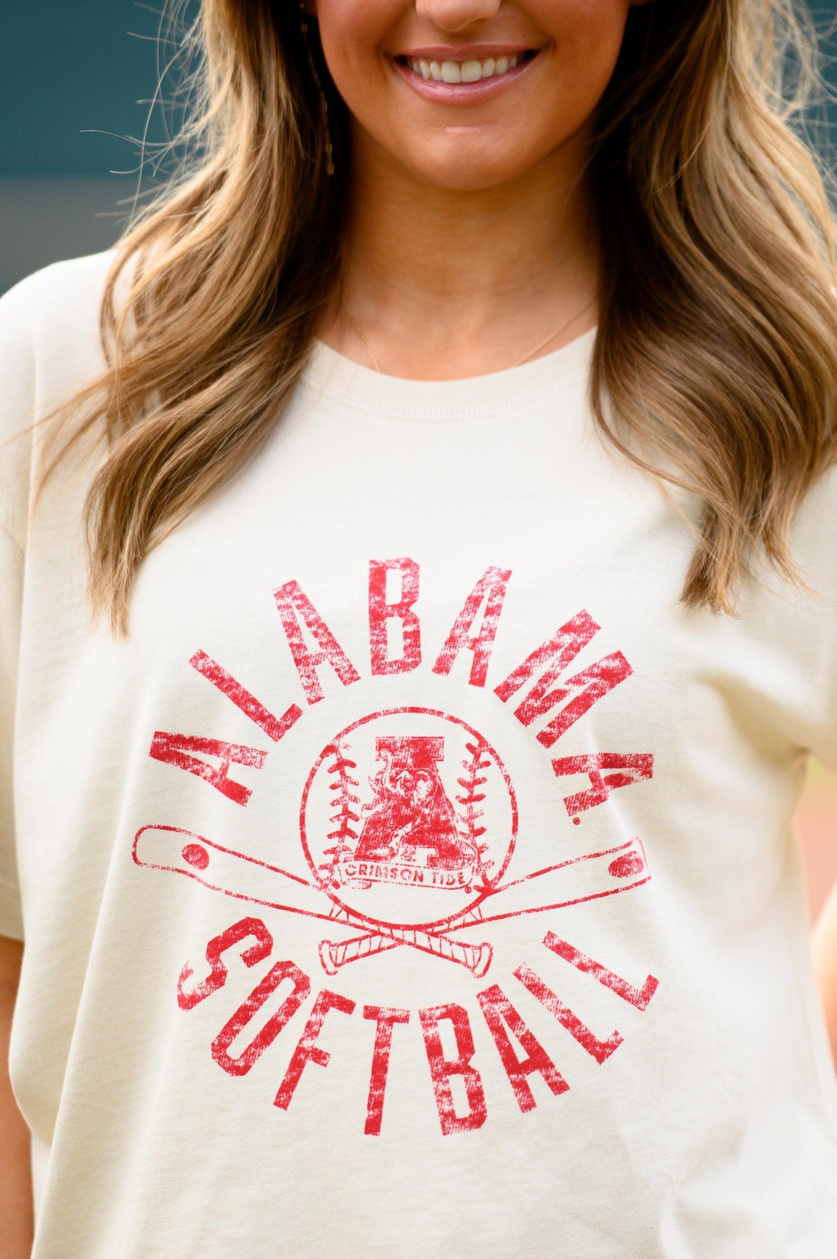 University of Alabama Distressed Ivory T-Shirt with a Red Softball featuring the Vintage A logo over crossed softball bats, surrounded by Red text “Alabama Softball”