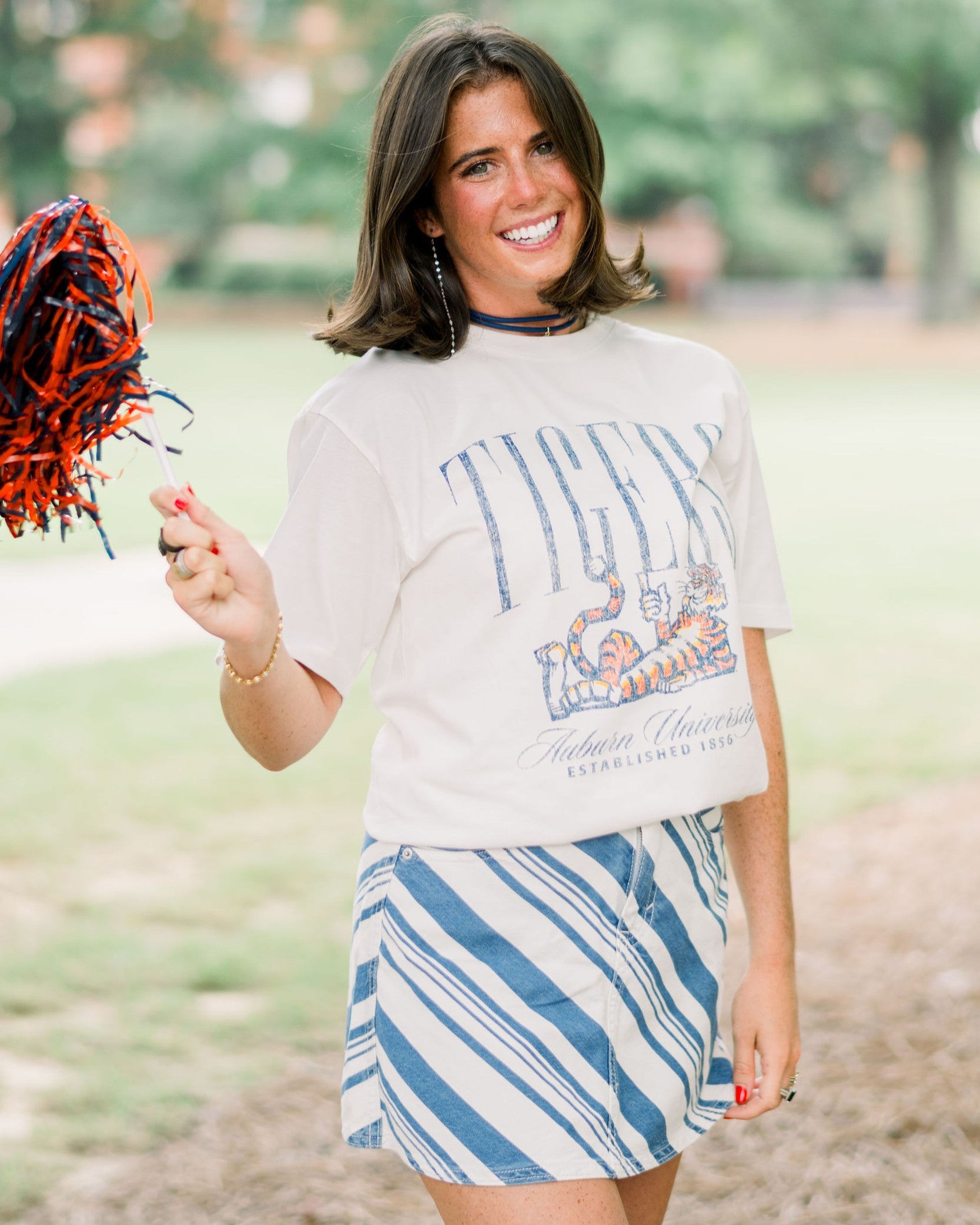 Auburn University Ivory T-Shirt with navy text “Tigers” above Aubie laying down