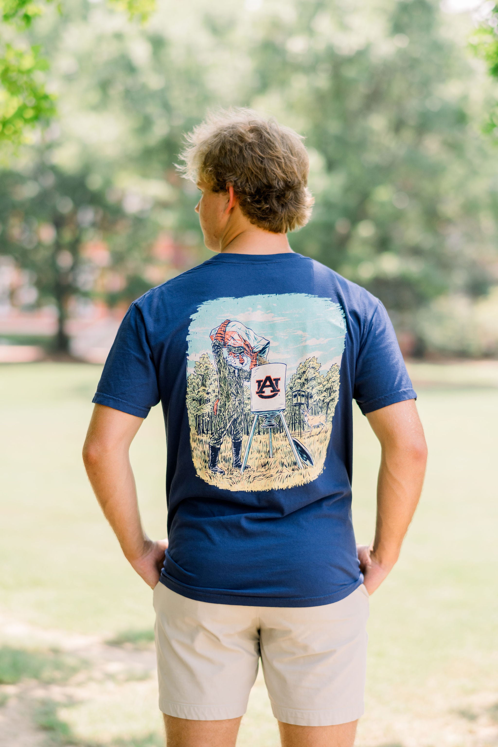 Auburn University Navy T-Shirt with an image of Aubie wearing hunting gear and filling an AU Branded deer feeder