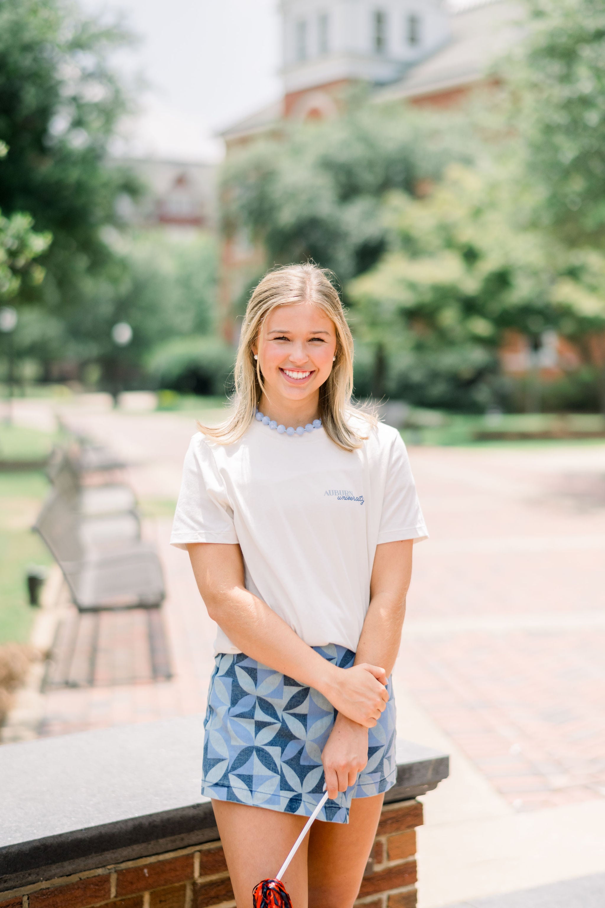 Auburn University White Ladies Tee with a vintage Blue illustration of cowgirl boots with bows tied on them above Blue text “Home On The Plains”