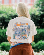 Auburn University Ivory T-Shirt with text “Auburn University” above an illustration of a tiger prowling in front of a collage of auburn icons such as Sanford Hall, Jordan Hare Stadium, and Tiger Walk