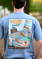 Auburn University Auburn 2024 Football Schedule Blue Comfort Colors T-Shirt With an image of a football stadium below a string of flags reading the 2024 football schedule  
