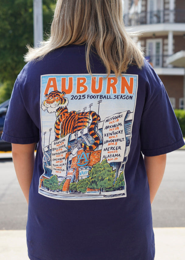 Auburn University Navy T-Shirt with an image of Aubie laying on the stadium and painting the Auburn football schedule on two banners