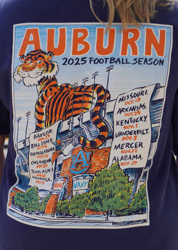 Auburn University Navy T-Shirt with an image of Aubie laying on the stadium and painting the Auburn football schedule on two banners