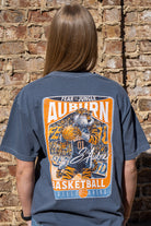 Auburn University Dark Blue T-Shirt with a basketball card style design featuring Aubie dribbling a basketball down the court in between text “Fear the Jungle Auburn” and “Basketball Neville Arena” and with an autograph from “Sir Aubie”