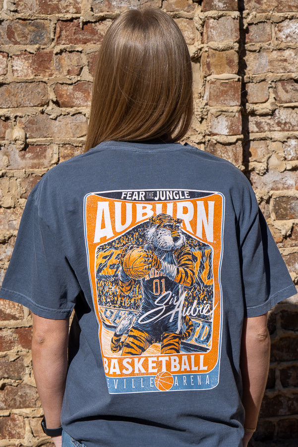 Auburn University Dark Blue T-Shirt with a basketball card style design featuring Aubie dribbling a basketball down the court in between text “Fear the Jungle Auburn” and “Basketball Neville Arena” and with an autograph from “Sir Aubie”