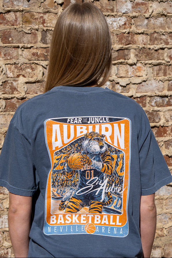 Auburn University Dark Blue T-Shirt with a basketball card style design featuring Aubie dribbling a basketball down the court in between text “Fear the Jungle Auburn” and “Basketball Neville Arena” and with an autograph from “Sir Aubie”