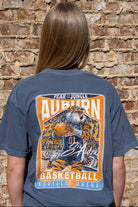 Auburn University Dark Blue T-Shirt with a basketball card style design featuring Aubie dribbling a basketball down the court in between text “Fear the Jungle Auburn” and “Basketball Neville Arena” and with an autograph from “Sir Aubie”
