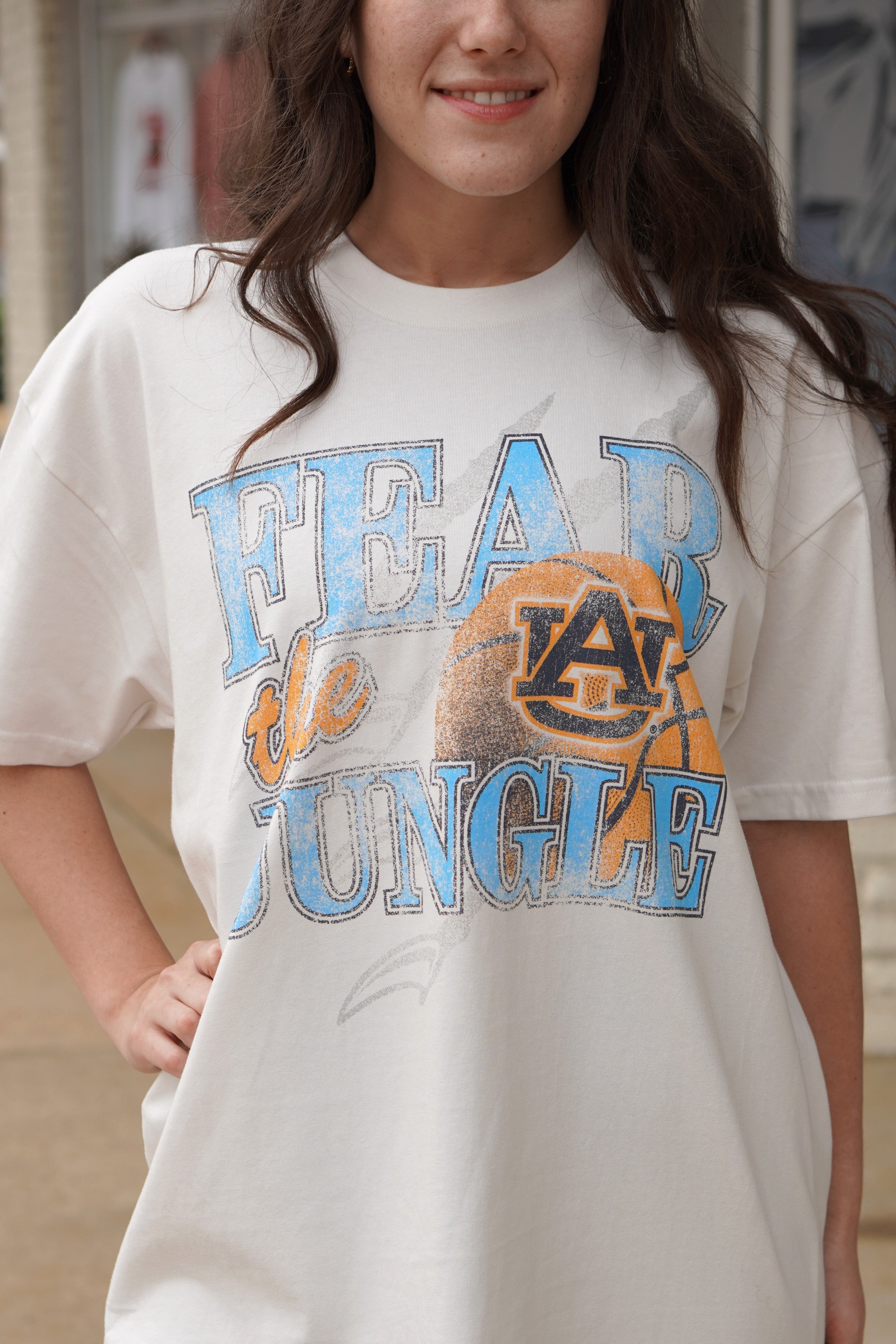 Auburn University Off-White T-Shirt with 'FEAR THE JUNGLE' text, a basketball with the AU Logo and tiger claw marks design
