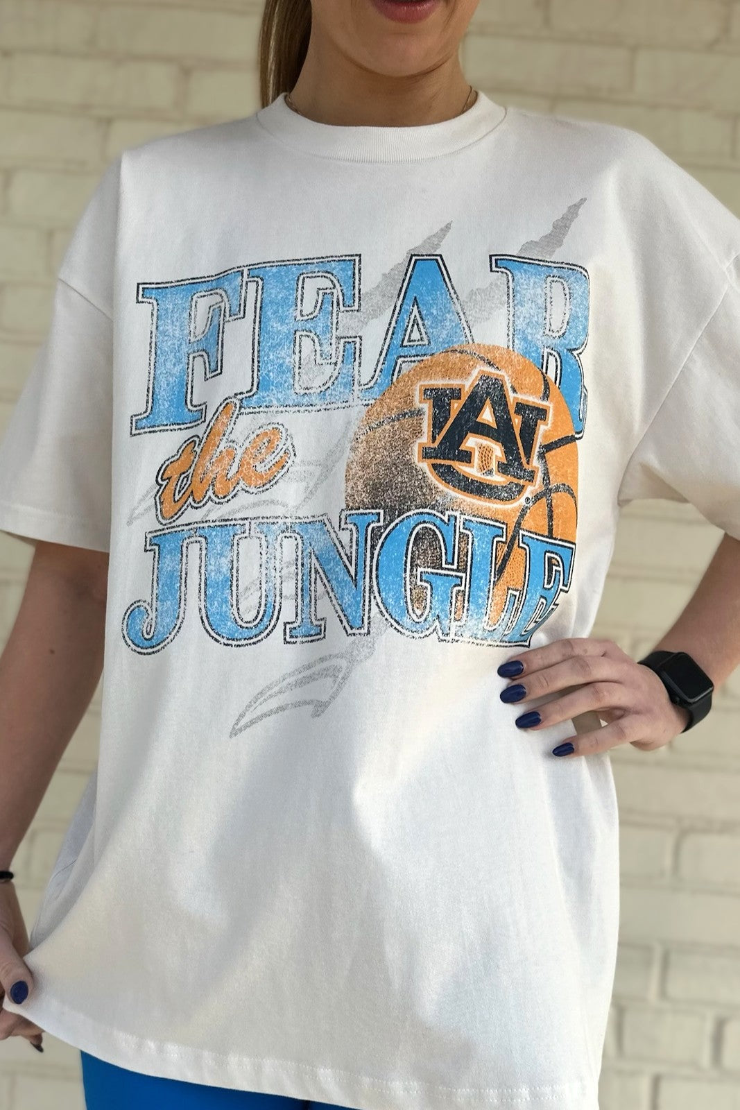 Auburn University Off-White T-Shirt with 'FEAR THE JUNGLE' text, a basketball with the AU Logo and tiger claw marks design