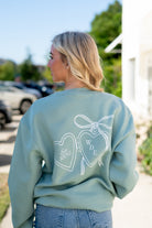Auburn University Seafoam Crewneck with cursive writing on the front and an open locket with the writing “WDE” inside on the back