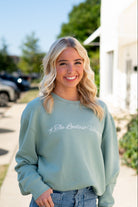 Auburn University Seafoam Crewneck with cursive writing on the front and an open locket with the writing “WDE” inside on the back