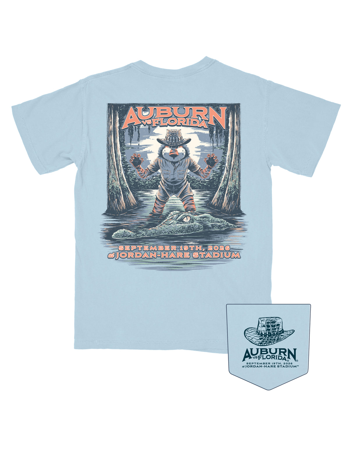 Auburn University Light Blue Shirt with an image of Aubie standing in a moonlit swamp, wearing an alligator skin hat and a khaki shirt and shorts, ready to pounce on a passing Gator