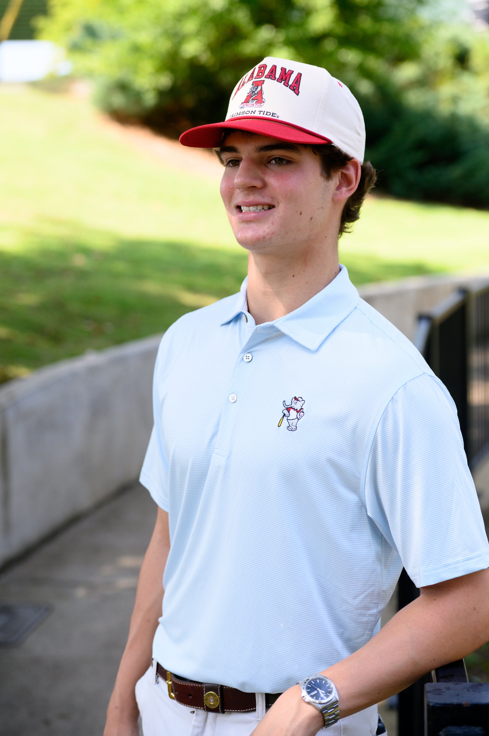 University of Alabama BallPlayer Al Men's Light Blue Performance Polo with an embroidered image of Big Al in a baseball uniform leaning on a baseball bat