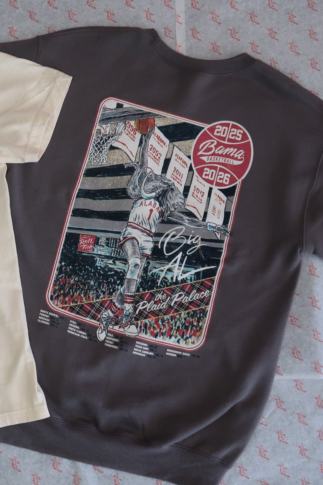 University of Alabama Dark Grey Sweatshirt with an illustration of Big Al dunking a basketball next to text “Big Al” and “the Plaid Palace” above the 2025 Basketball Schedule