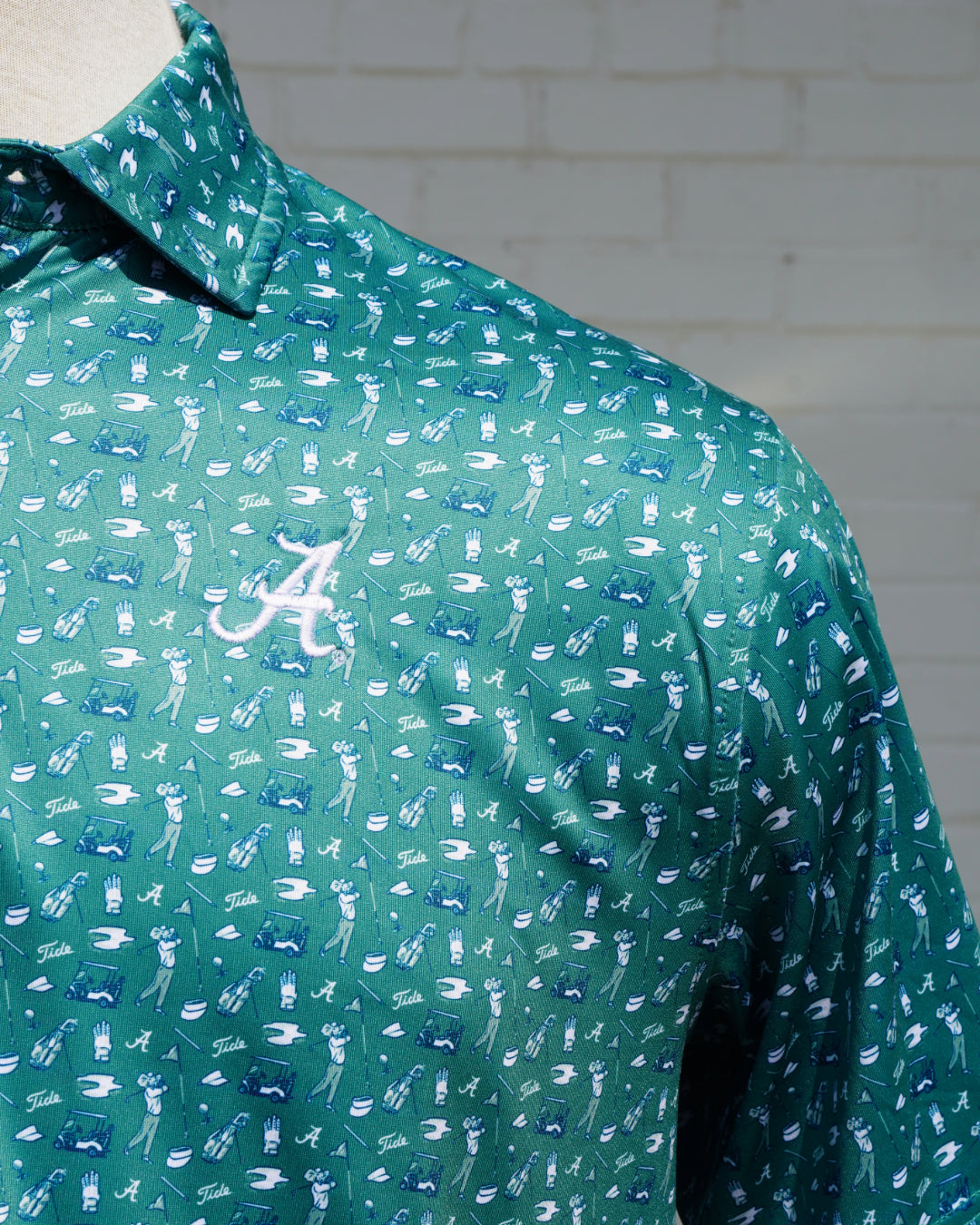 University of Alabama Bama Tee Time Green Men's JNJ Performance Polo with a pattern of small golf-themed graphics and Grey "Script A" Embroidery