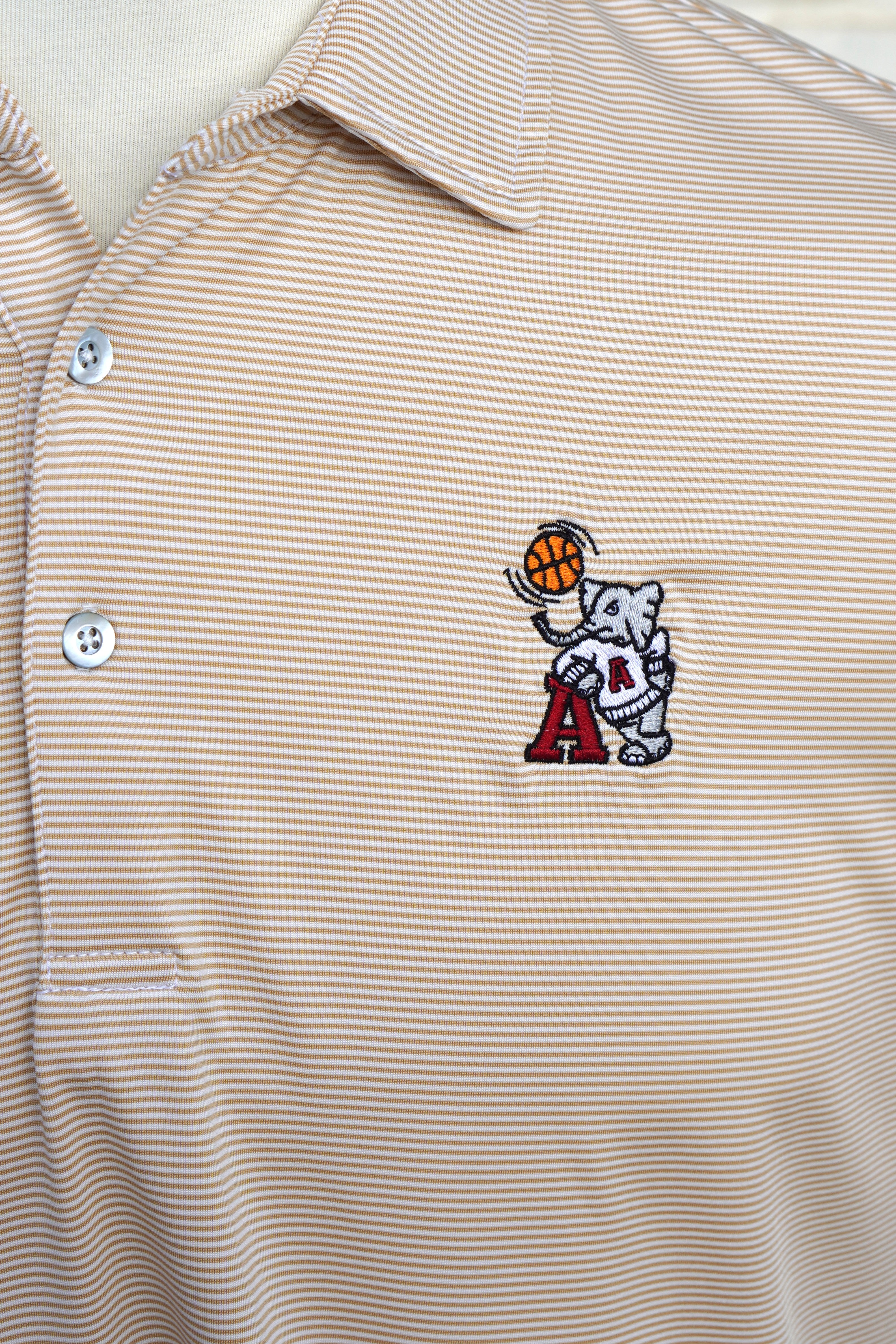 University of Alabama Basketball Al Tan Men’s Polo with an embroidered Big Al in a sweater holding a basketball and leaning against an "A"