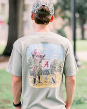 University of Alabama Sandstone T-Shirt with an illustration of Big Al in hunting gear filling a Script A deer feeder with a deer in the background