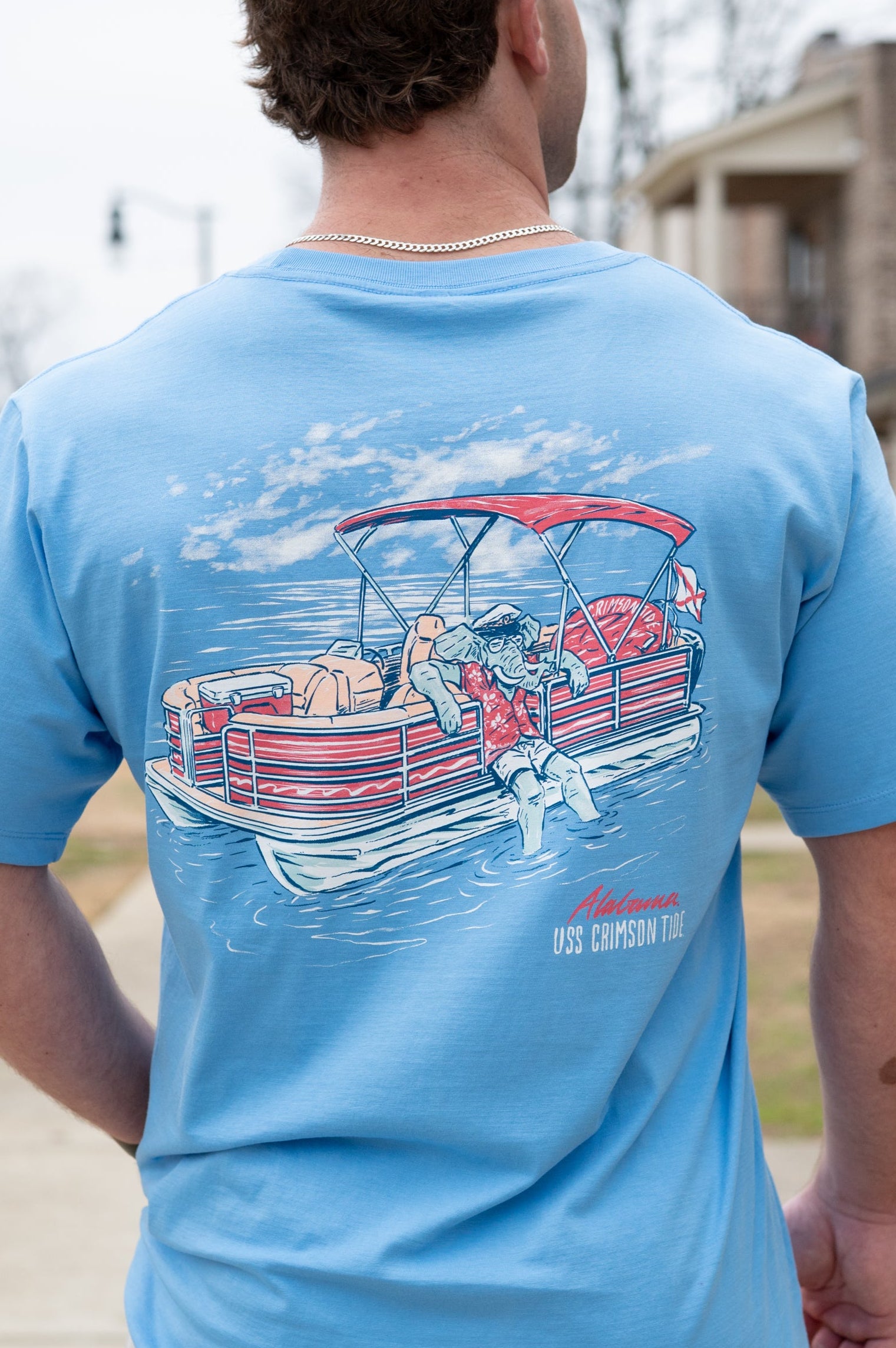 University of Alabama Big Al Pontoon Azure Comfort Colors T-Shirt with an image of Big Al lounging on the side of a Red and White Pontoon Boat  with the text "USS Crimson Tide" below