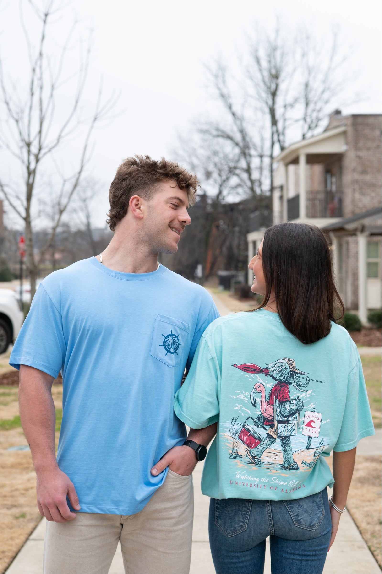 A man wearing the "Big Al Pontoon" linking arms with a woman wearing the "Big Al Beach" shirt 